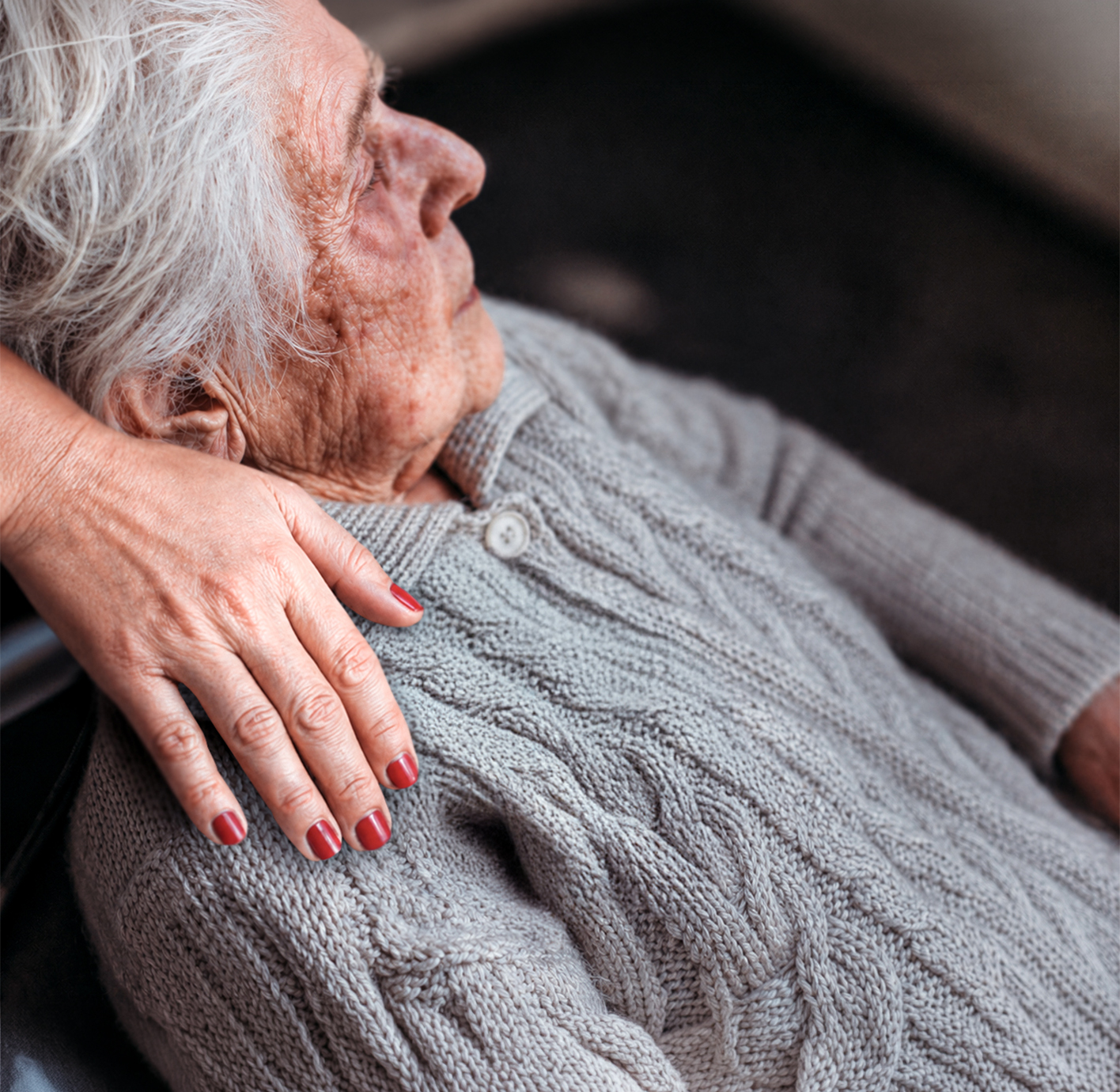 Elderly woman receiving gentle support.