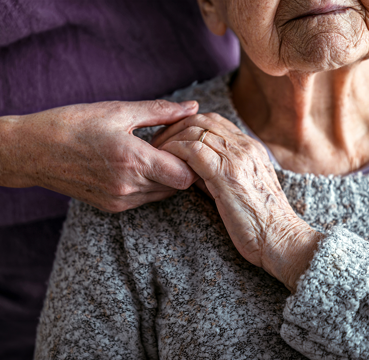Caregiver comforting an elderly woman.